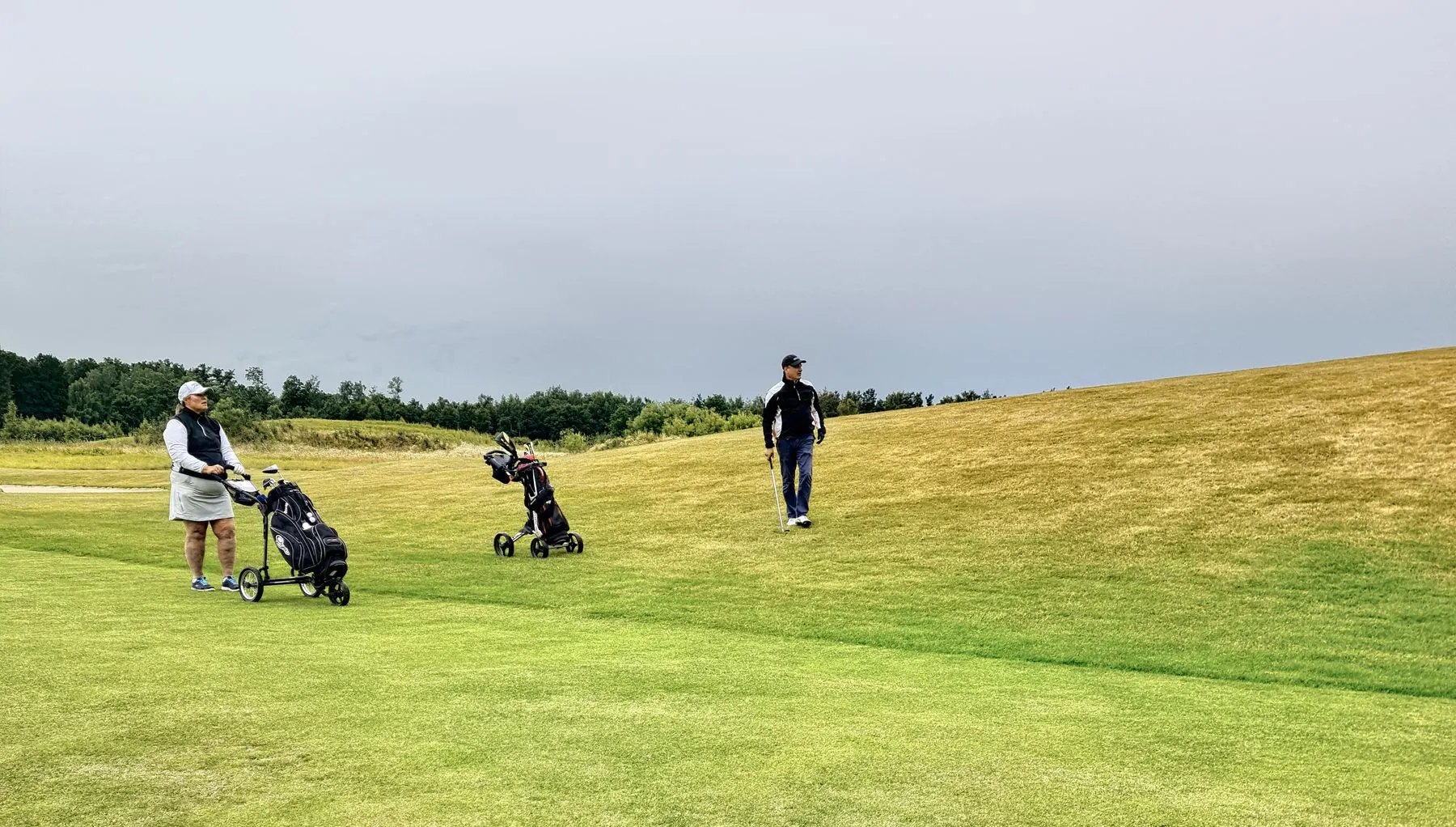 Golfers walking together across an open course