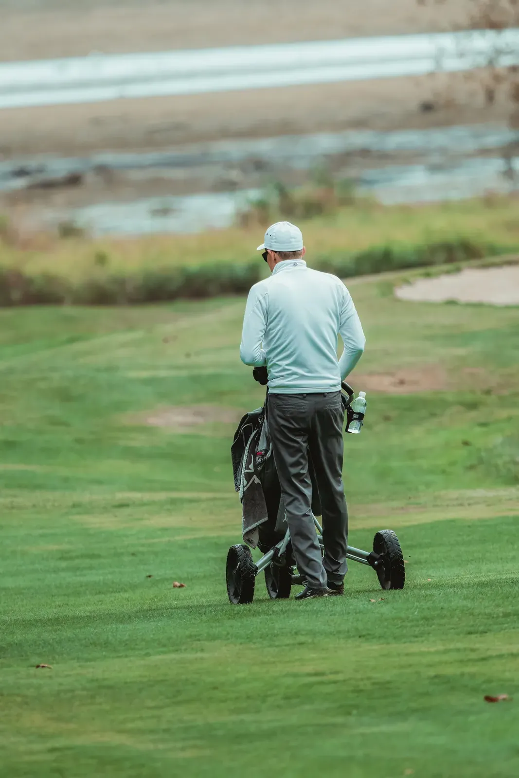 A golfer walking away after completing a hole